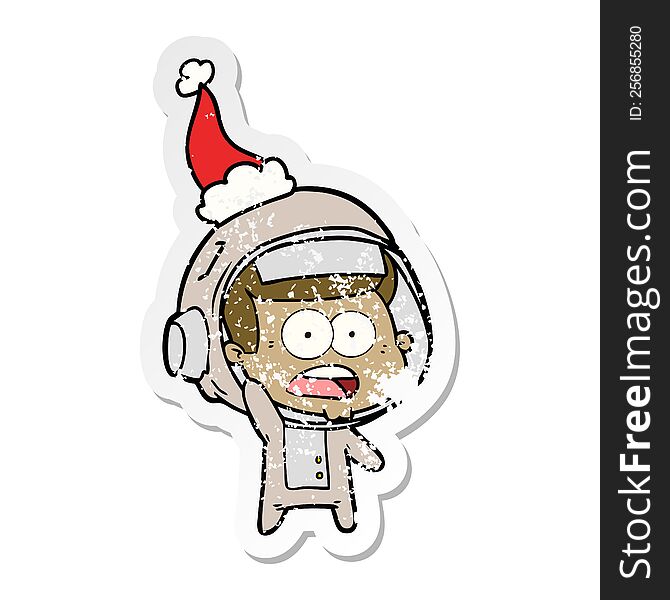 Distressed Sticker Cartoon Of A Surprised Astronaut Wearing Santa Hat