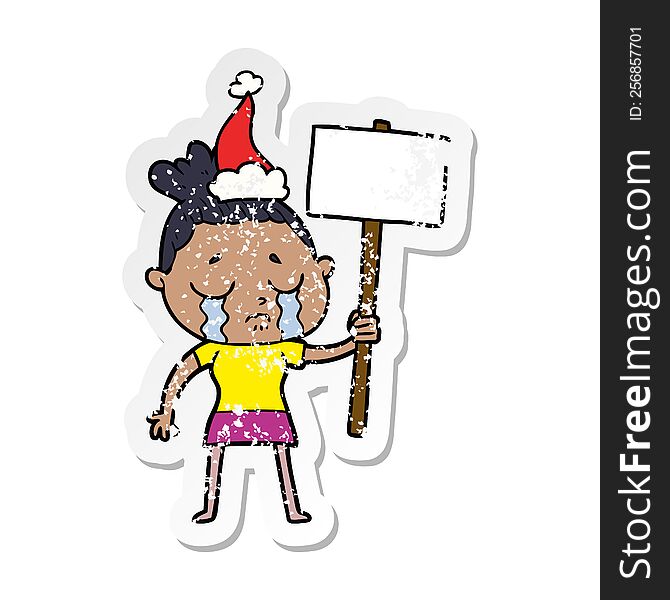 Distressed Sticker Cartoon Of A Crying Woman With Protest Sign Wearing Santa Hat