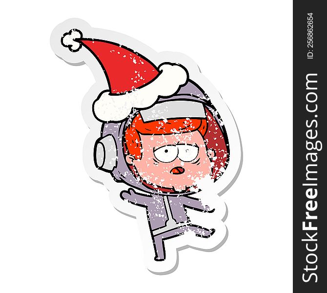 hand drawn distressed sticker cartoon of a tired astronaut wearing santa hat