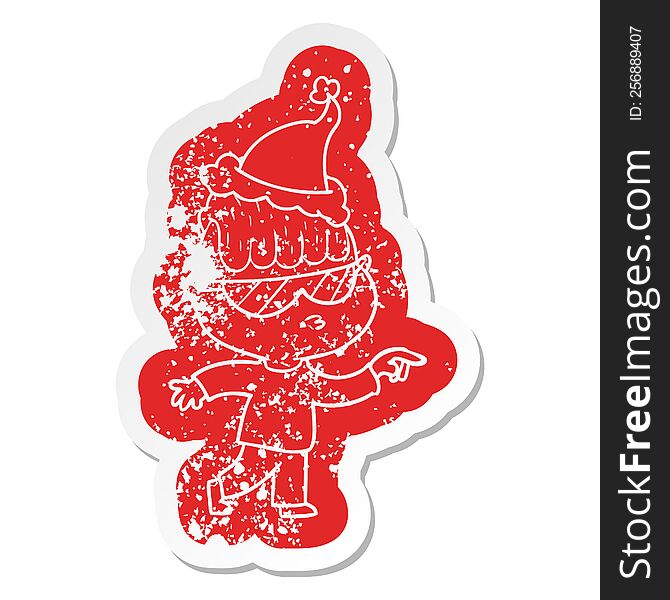 cartoon distressed sticker of a boy wearing sunglasses pointing wearing santa hat