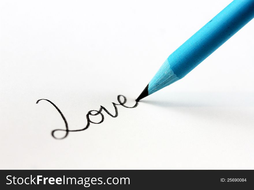 A high key image of blue lead pencil writing the cursive word love on a sheet of paper. A high key image of blue lead pencil writing the cursive word love on a sheet of paper.