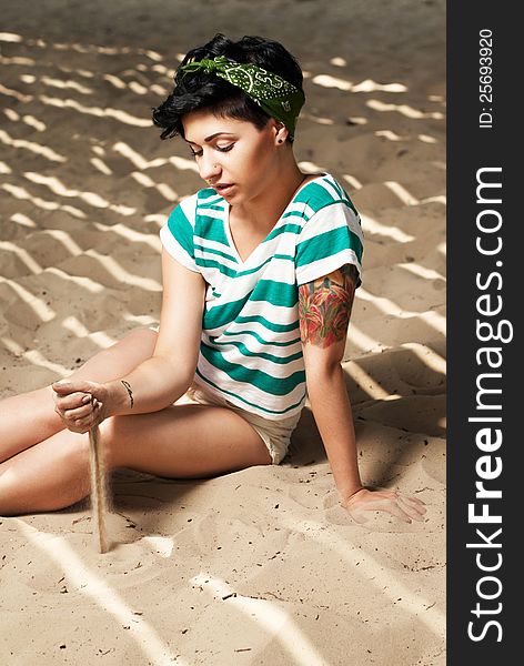 Girl With Tattoo On The Beach Pours Sand