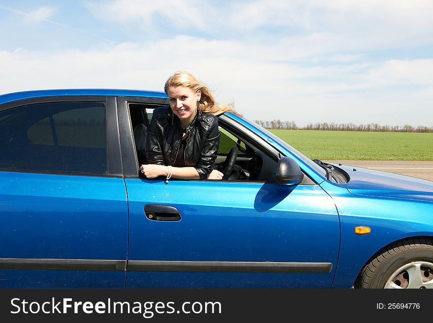 Happy girl in the dark blue car. Happy girl in the dark blue car