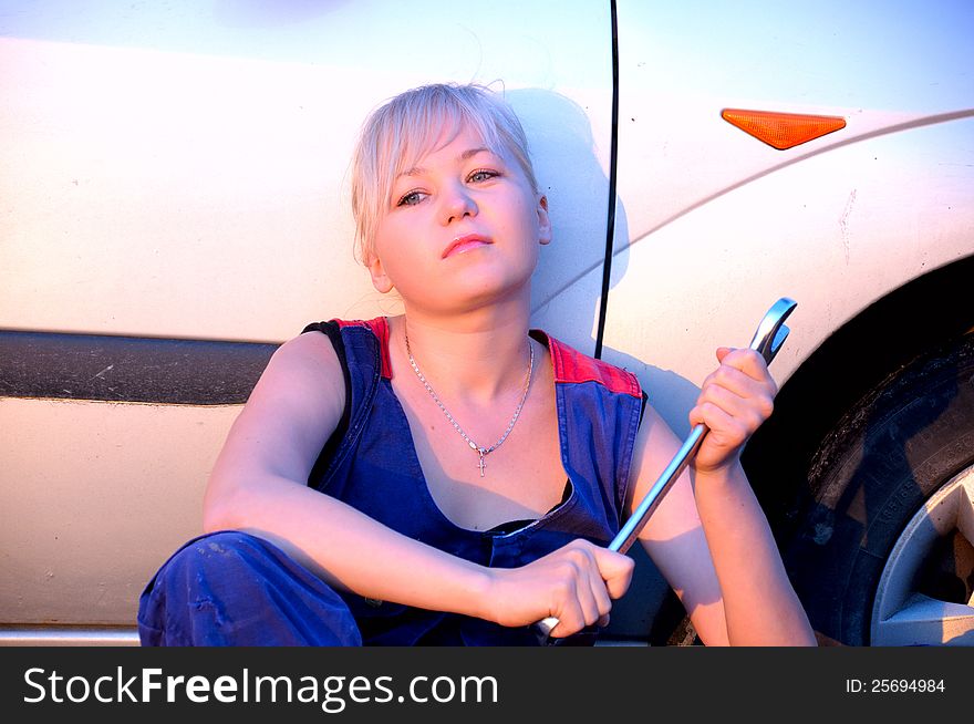 Beautiful young woman repairing the car