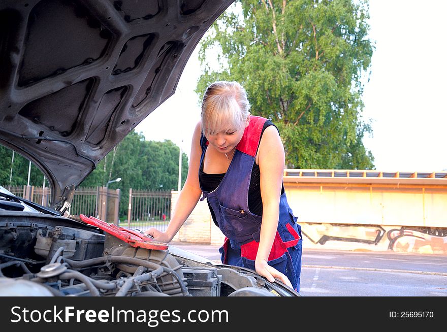 Beautiful young woman repairing the car