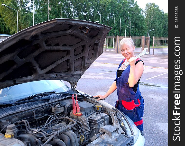 Beautiful young woman repairing the car