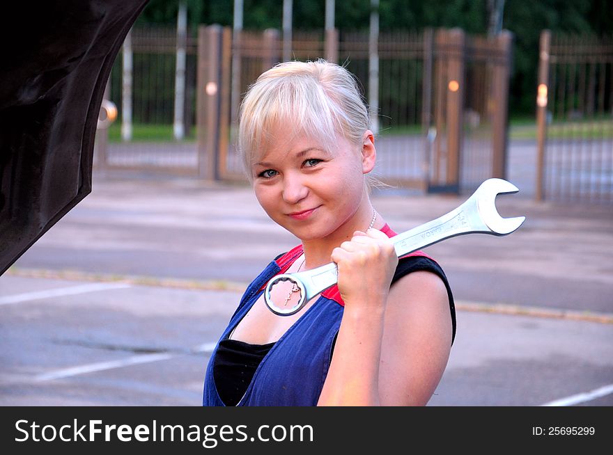 Beautiful young woman repairing the car