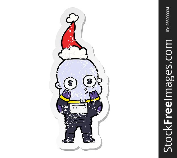 Distressed Sticker Cartoon Of A Weird Bald Spaceman Wearing Santa Hat