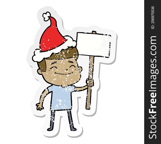 Happy Distressed Sticker Cartoon Of A Man With Placard Wearing Santa Hat
