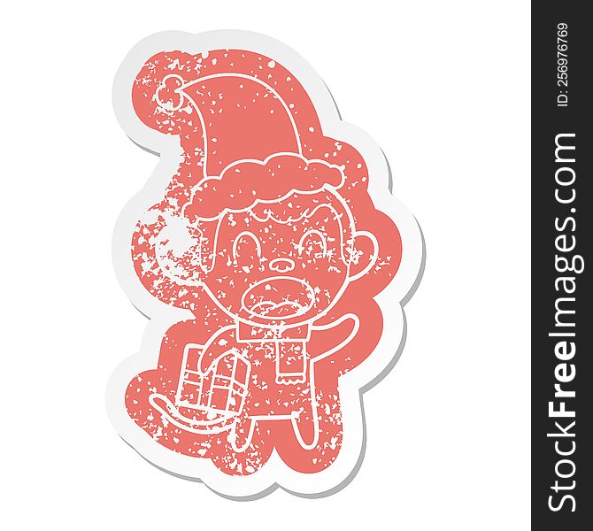shouting quirky cartoon distressed sticker of a monkey carrying christmas gift wearing santa hat