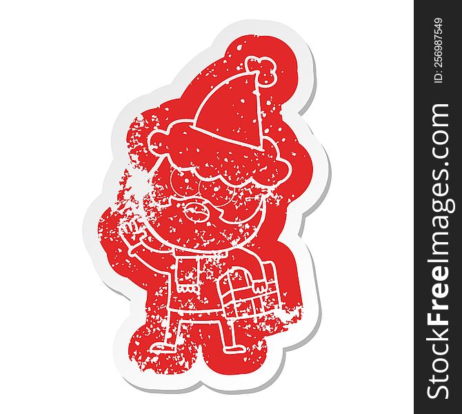 Cartoon Distressed Sticker Of A Bearded Man With Present Wearing Santa Hat
