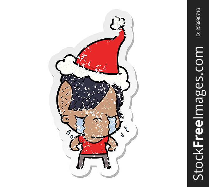 hand drawn distressed sticker cartoon of a crying girl wearing santa hat