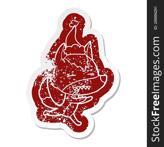 quirky cartoon distressed sticker of a wolf showing teeth wearing santa hat