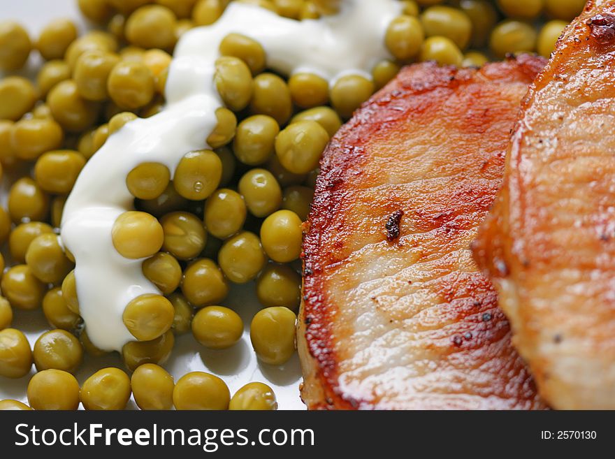 Fried pork and green peas with sauce close-up