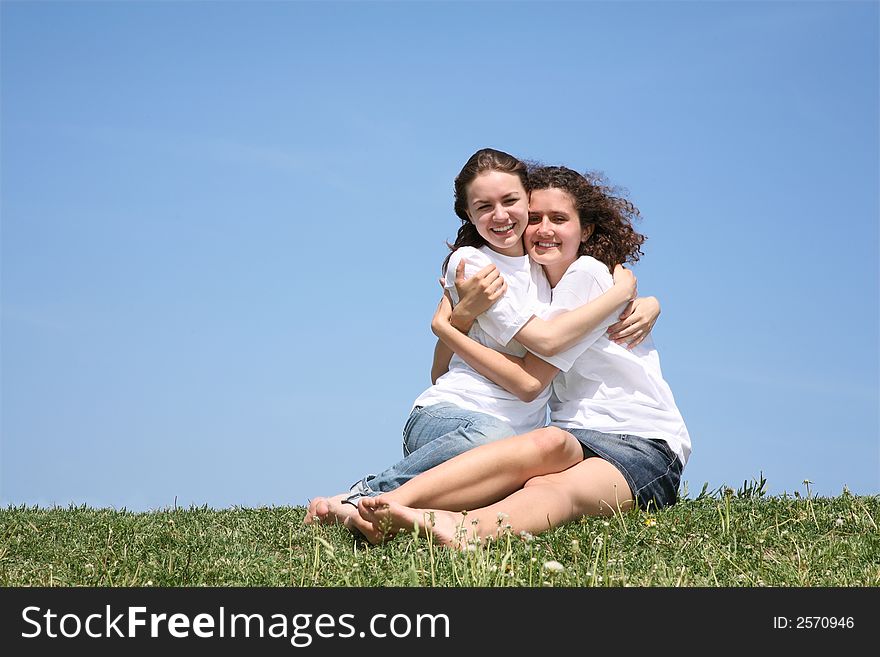 Two girlfriends in white T-shorts embrace