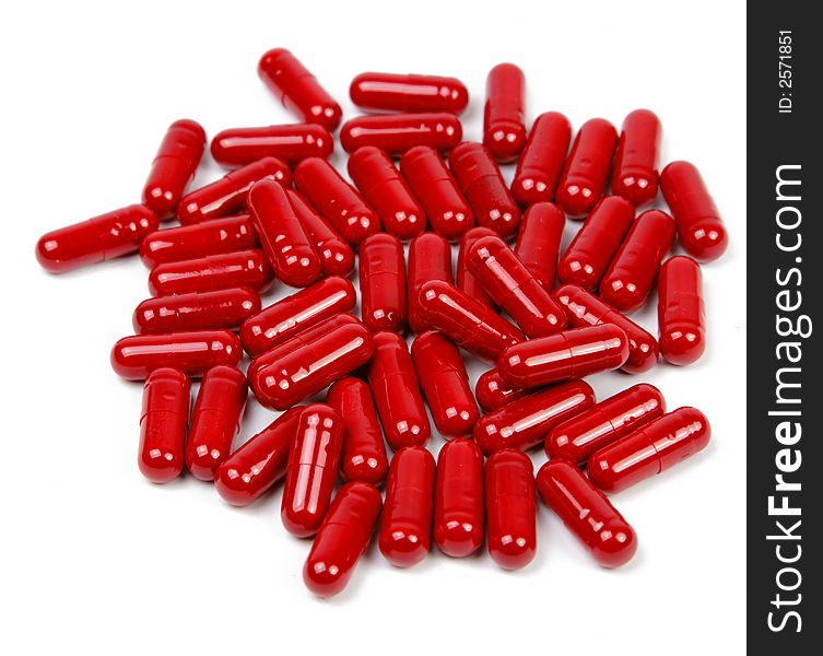 Red capsules upper view over white background.