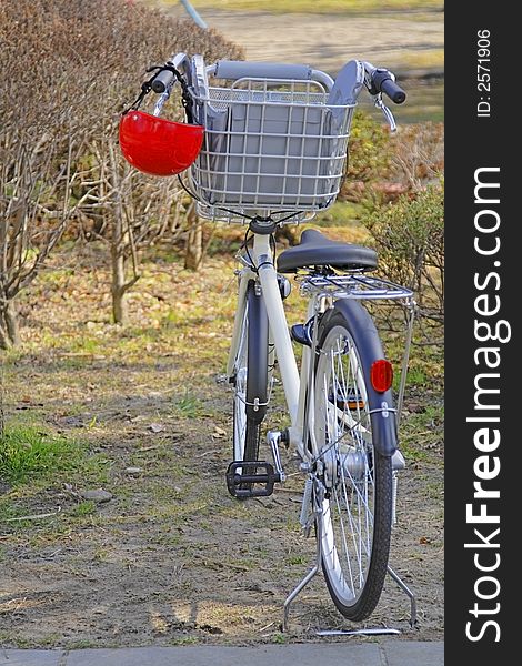 Image of a bicycle with a kid helmet hanging down in a park. Image of a bicycle with a kid helmet hanging down in a park.