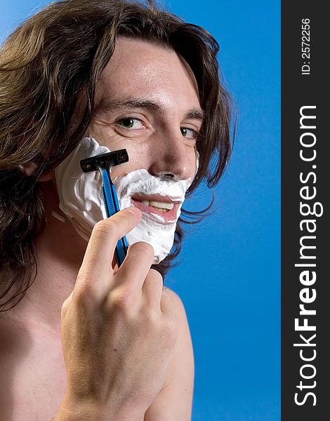 Young man portrait shaving himself. Young man portrait shaving himself