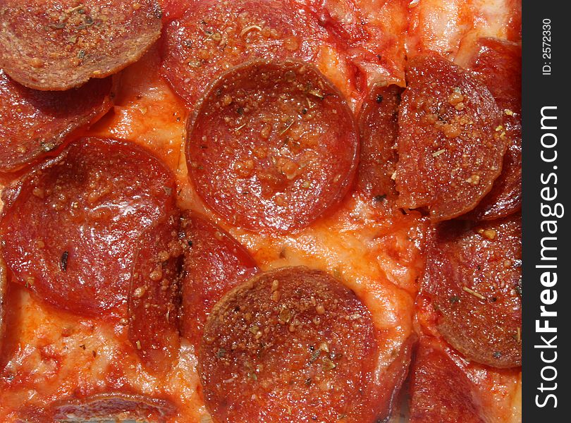 Bright close-up of pepperonies and cheese on pizza. Bright close-up of pepperonies and cheese on pizza