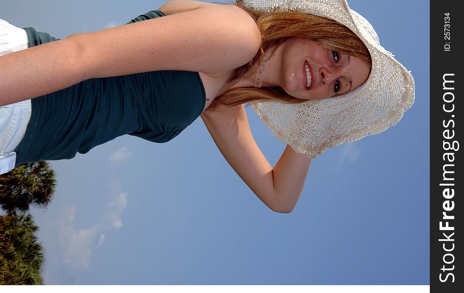 A pretty smiling girl in a sun hat outdoors. A pretty smiling girl in a sun hat outdoors