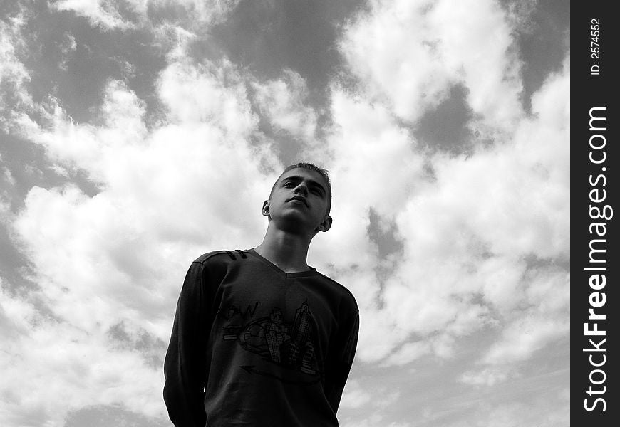 The boy stands on a sky background. The boy stands on a sky background