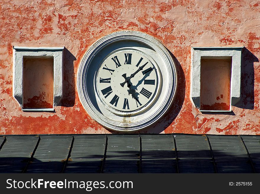 An old style clock on a pink wall. An old style clock on a pink wall