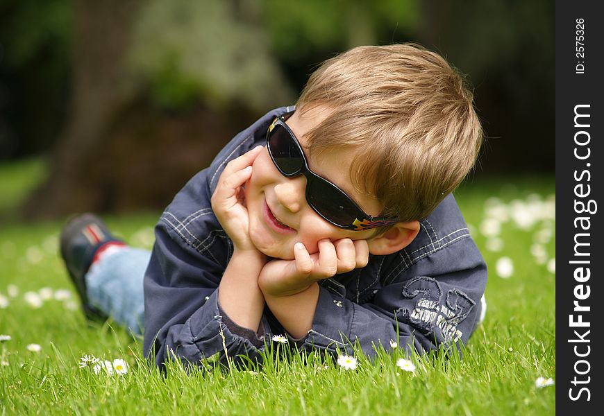 Boy sleeping ion the green grass field.