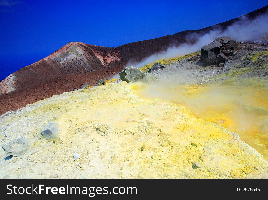 Rocks, smoke and sulphur on the volcano by a sunny day.