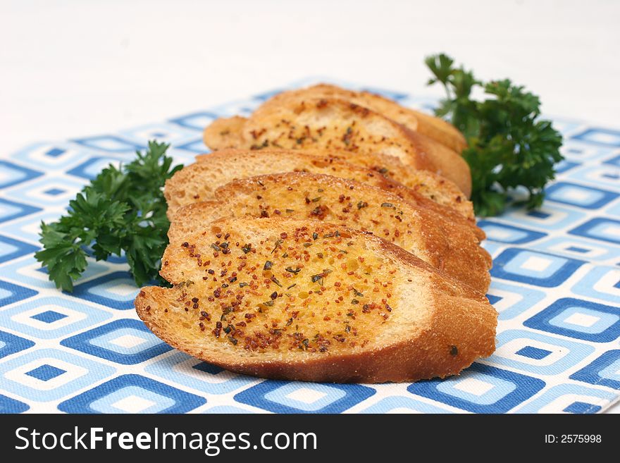 Garlic bread slices laid on a retro blue squared table-mat