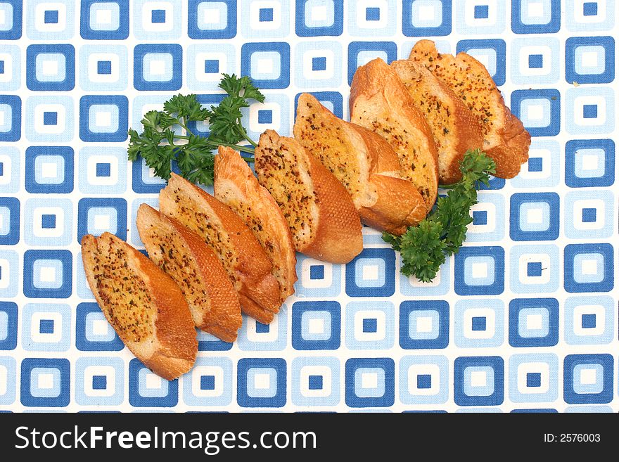 Garlic bread slices laid on a retro blue squared table-mat
