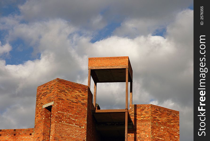 The top part of a under construction brick building with a platform on a roof. The top part of a under construction brick building with a platform on a roof.