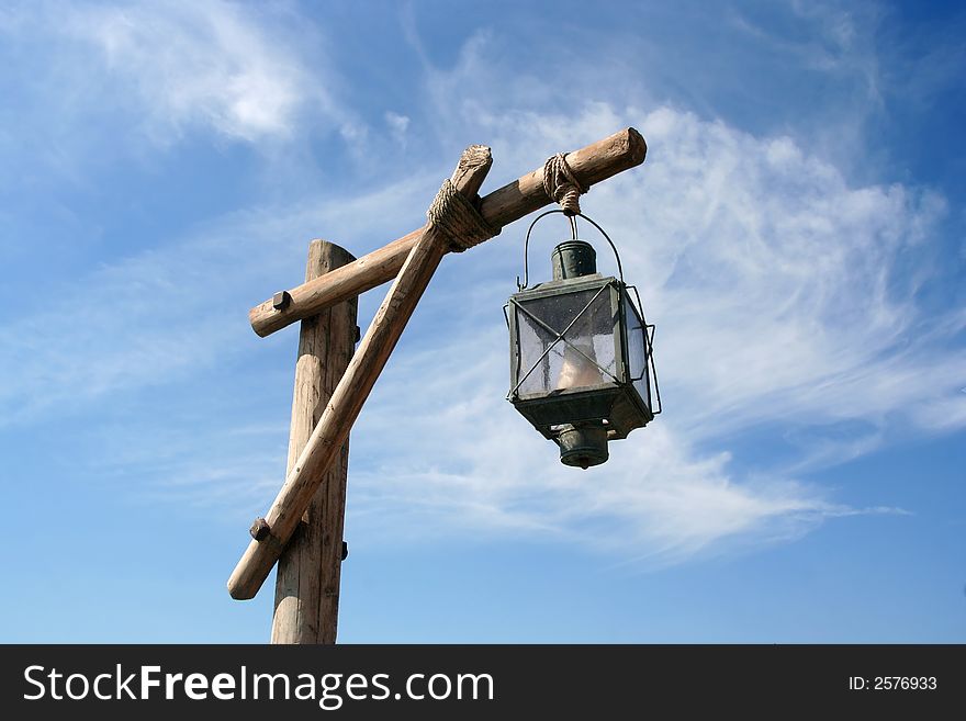 Old lantern hanging from a wooden pole