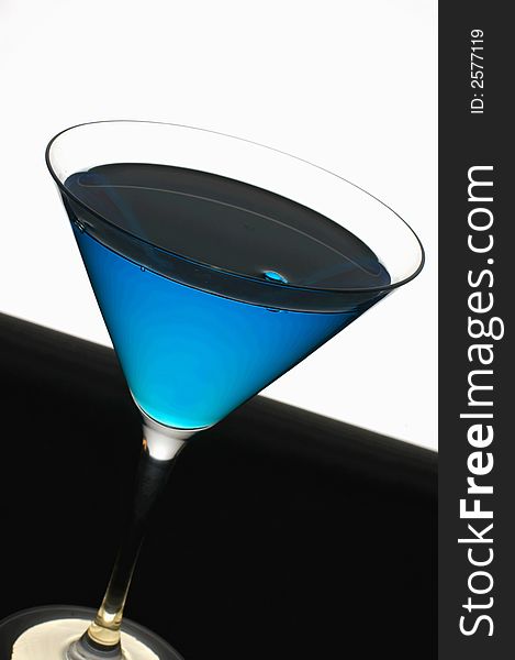 Simple but stylish mint blue cocktail against a white and black background. Simple but stylish mint blue cocktail against a white and black background.