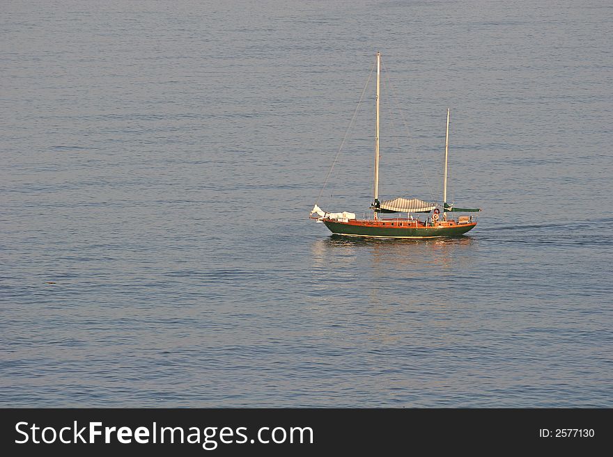 An old fishing boat heading out to sea at dawn. An old fishing boat heading out to sea at dawn