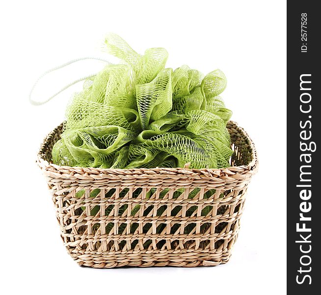 Green bath loofah in a basket - isolated on white