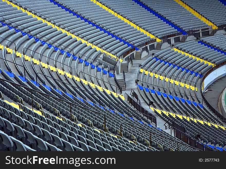 A field of empty grey plastic stadium seats.