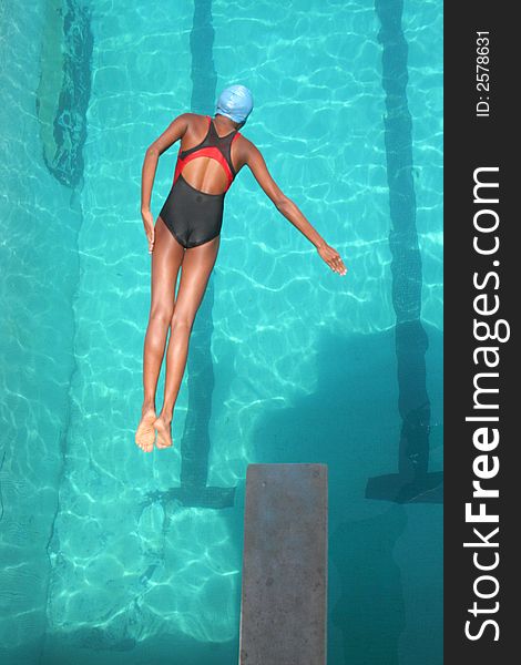 A young girl diving into the pool at a local state diving championship. A young girl diving into the pool at a local state diving championship