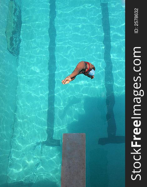 A young girl diving into the pool at a local state diving championship. A young girl diving into the pool at a local state diving championship