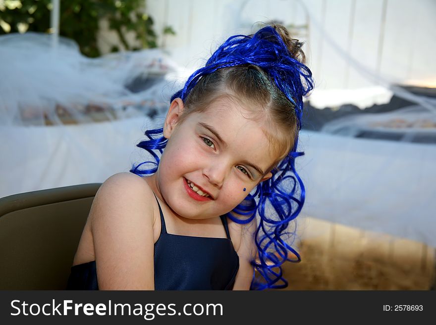 Young girl all dressed up in a glamorous gown with her hair made up, makeup, and glitter for her birthday party. Young girl all dressed up in a glamorous gown with her hair made up, makeup, and glitter for her birthday party