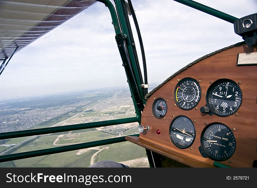 View of the city from the window of a small single engine airplane with the focus on the instrument panel. View of the city from the window of a small single engine airplane with the focus on the instrument panel.