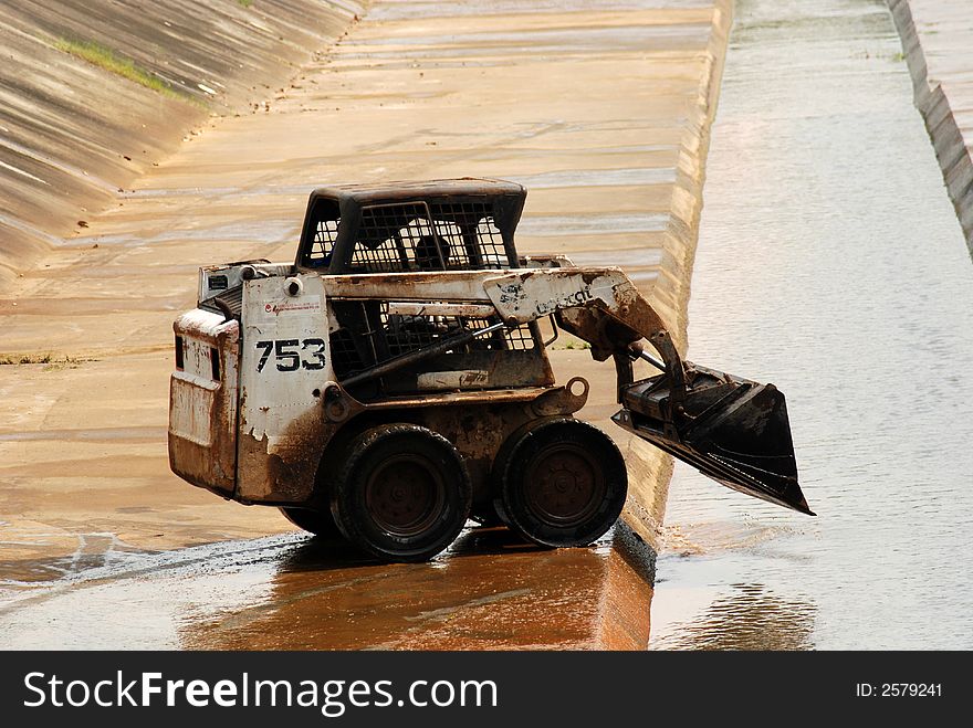 Worker and tractor cleaning the big drain