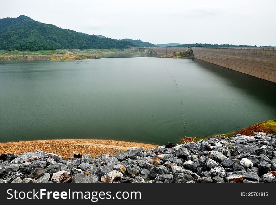 Long concrete dam lie in the montain with clam water. Long concrete dam lie in the montain with clam water.