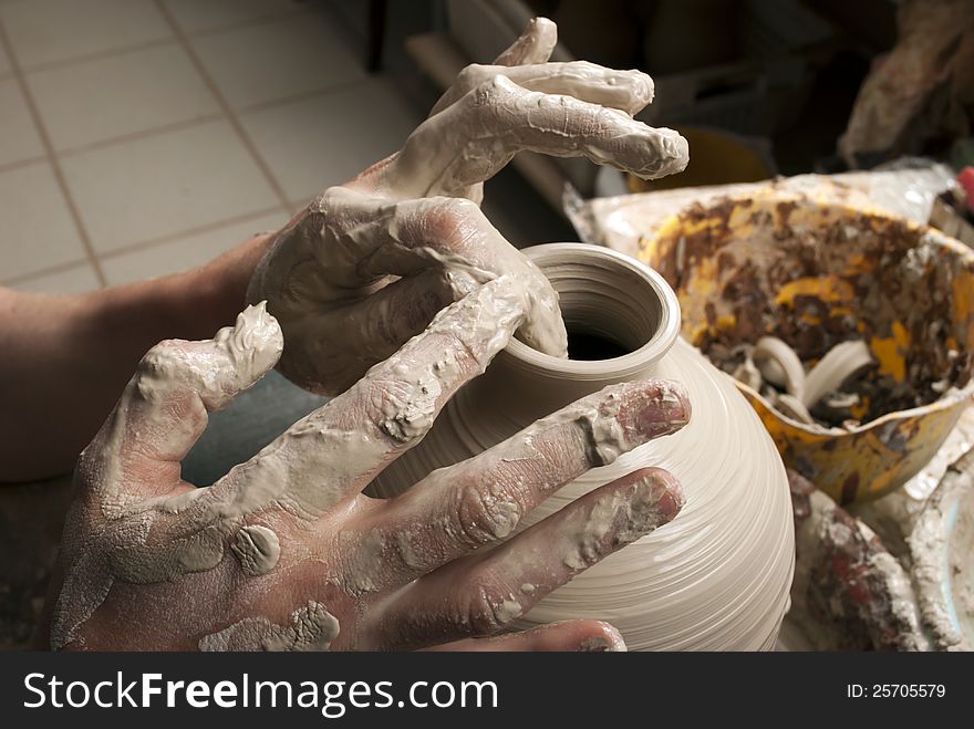 Hands of a potter, creating an earthen jar
