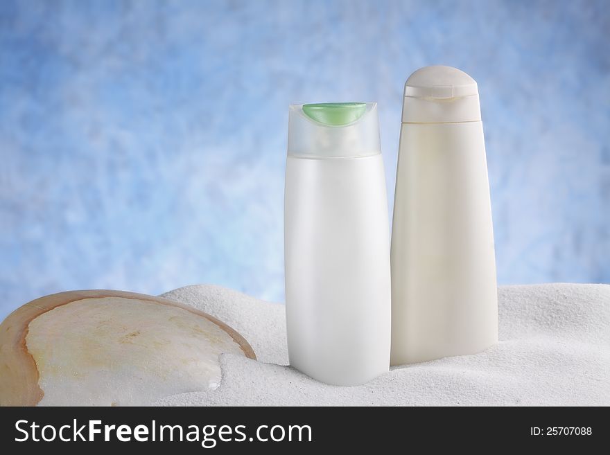 A group of beauty hygiene container with shell and dune on sky blue background