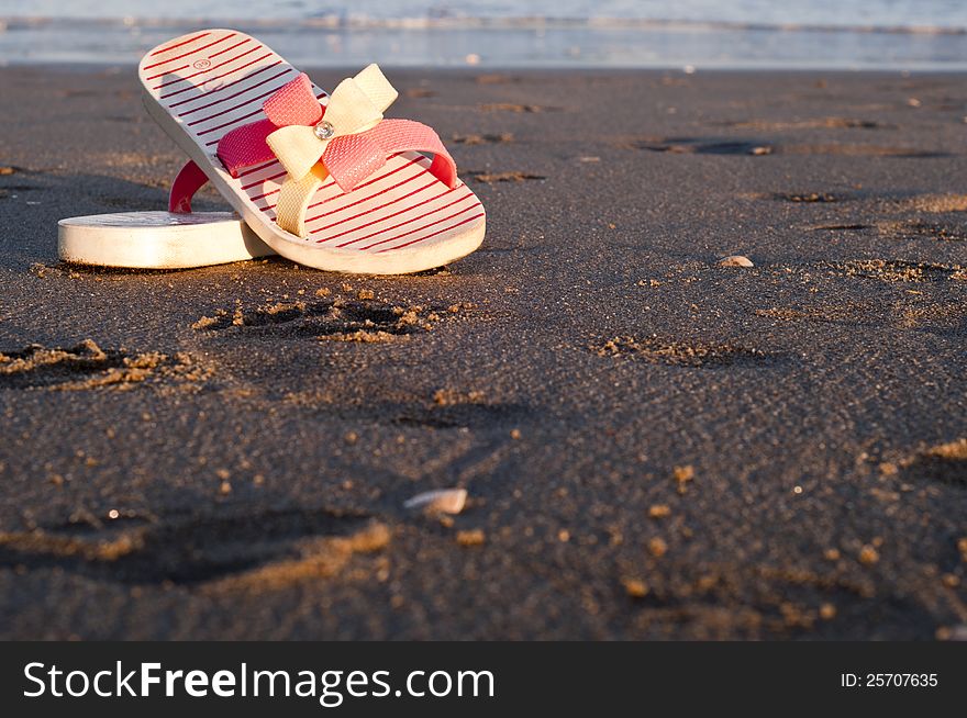 Flip-flops on the beach at sunset