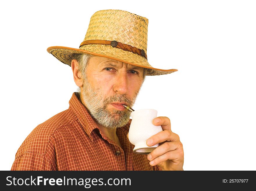 Horizontal portrait of a matured, graying, unshaved guy wearing a red shirt and a straw hut, drinking yerba mate from white ceramics. Horizontal portrait of a matured, graying, unshaved guy wearing a red shirt and a straw hut, drinking yerba mate from white ceramics.