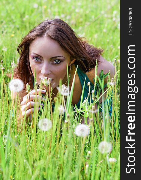 Cute young woman in the park with dandelions. Cute young woman in the park with dandelions