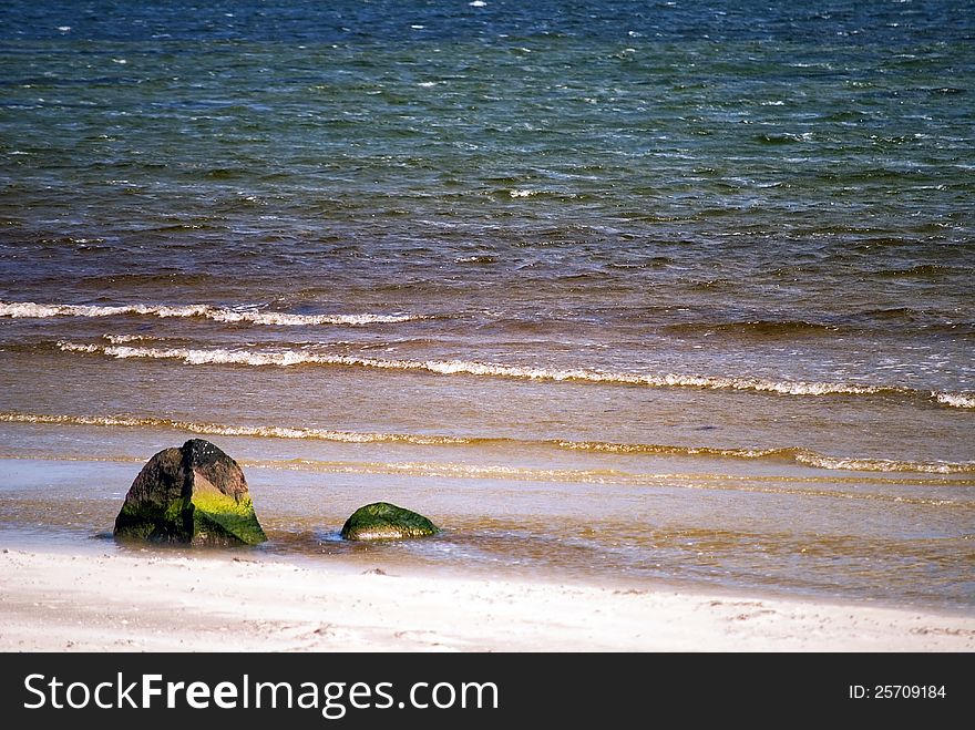 Sandy beach with rock and colorful water. Sandy beach with rock and colorful water