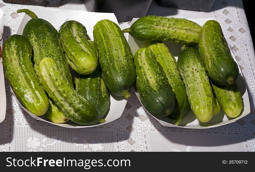 Pickle sized cucumbers in paper containers. Pickle sized cucumbers in paper containers