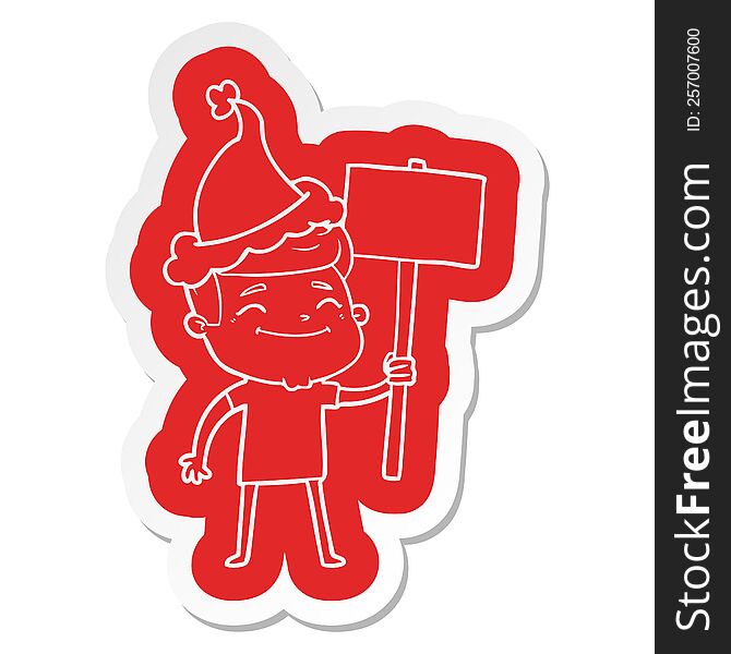 happy quirky cartoon  sticker of a man with placard wearing santa hat